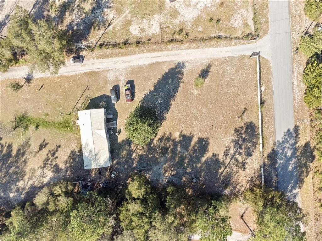 An aerial view shows a house on a large, partially wooded lot with two parked cars — 3230 SW 189TH AVENUE, DUNNELLON, FL
