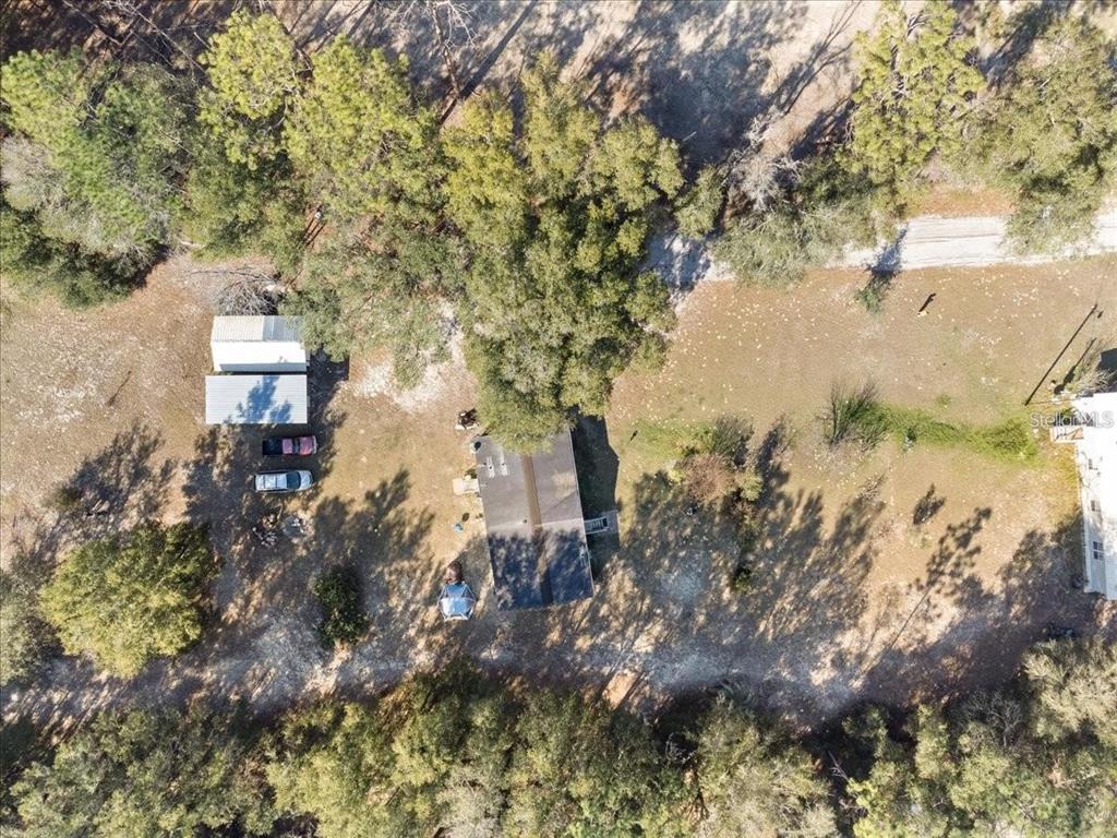 An aerial view shows a house, a detached shed, and several vehicles on a wooded lot — 3230 SW 189TH AVENUE, DUNNELLON, FL