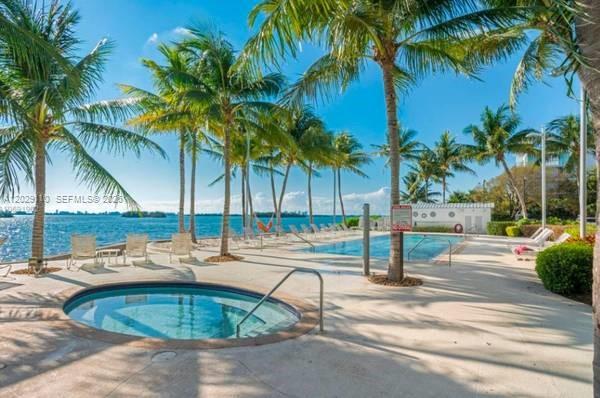 A circular hot tub sits on a concrete pool deck overlooking a bay with palm trees — 750 NE 64th St # B316, Miami FL 33138, MIAMI, FL