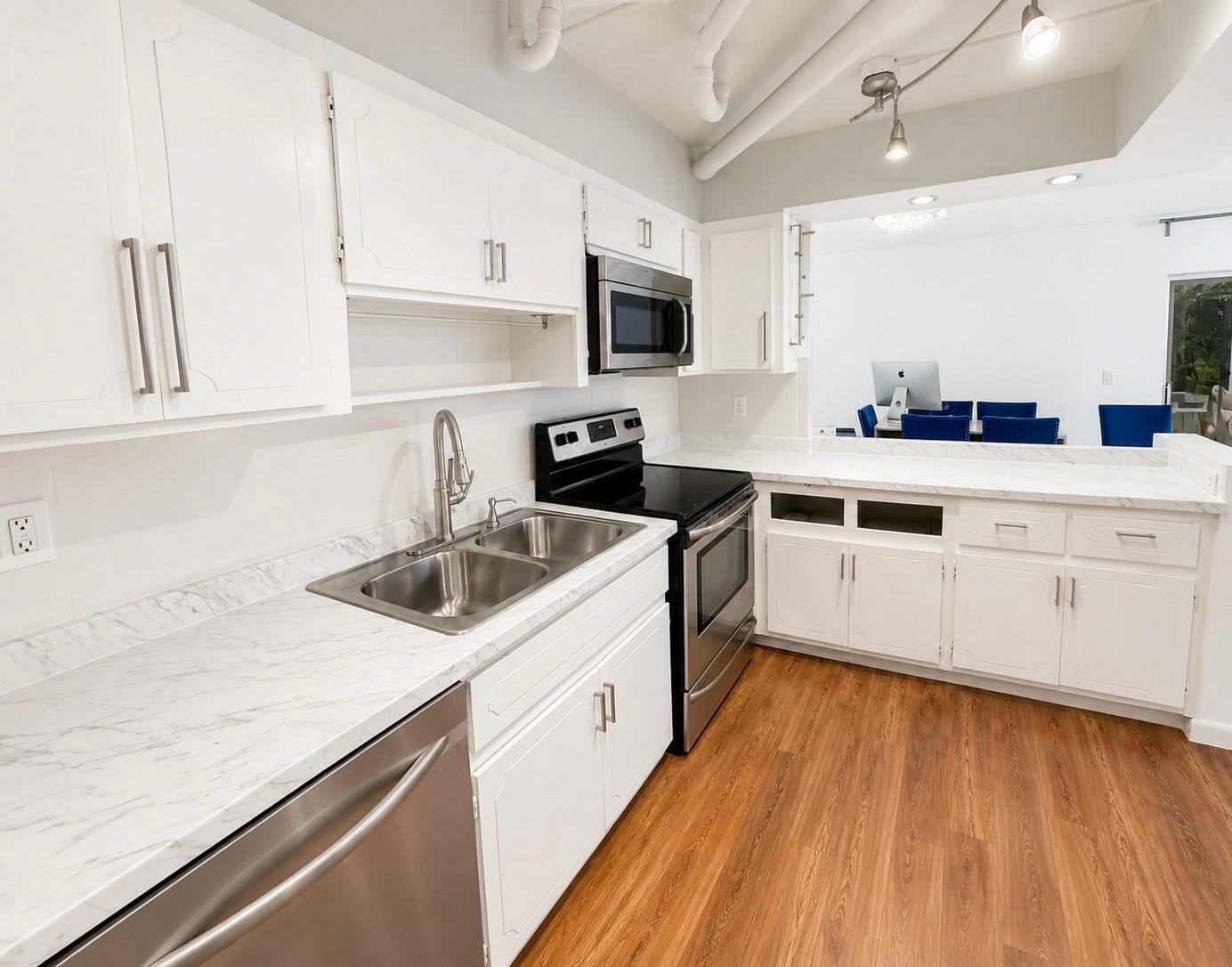 A kitchen with white cabinets, marble-look countertops, stainless steel appliances, and wood-style flooring — 6639 SW 41st Place # 41, Davie FL 33314, DAVIE, FL