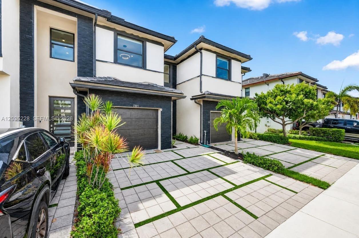 A two-story townhouse with a paved driveway, a garage, and modern exterior finishes — 15841 NW 91st Ct, Miami Lakes FL 33018, MIAMI LAKES, FL