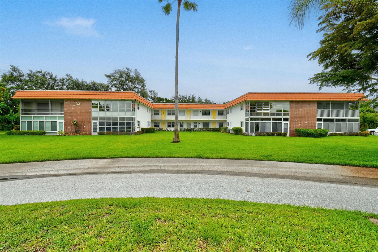 A two-story apartment building with a brick facade, orange roof, and a large front lawn — 1225 NW 21st Street # 314, Stuart FL 34994, STUART, FL