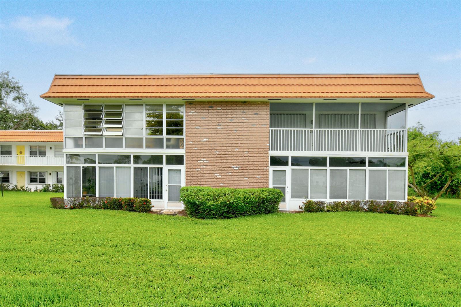 A two-story brick and glass apartment building features a tan roof and screened-in balconies — 1225 NW 21st Street # 314, Stuart FL 34994, STUART, FL