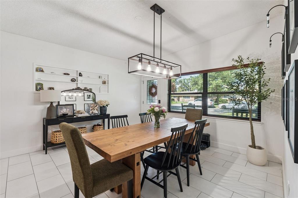 A dining room features a wooden table, black spindle chairs, and a rectangular pendant light — 4533 STILWELL DRIVE, ORLANDO, FL