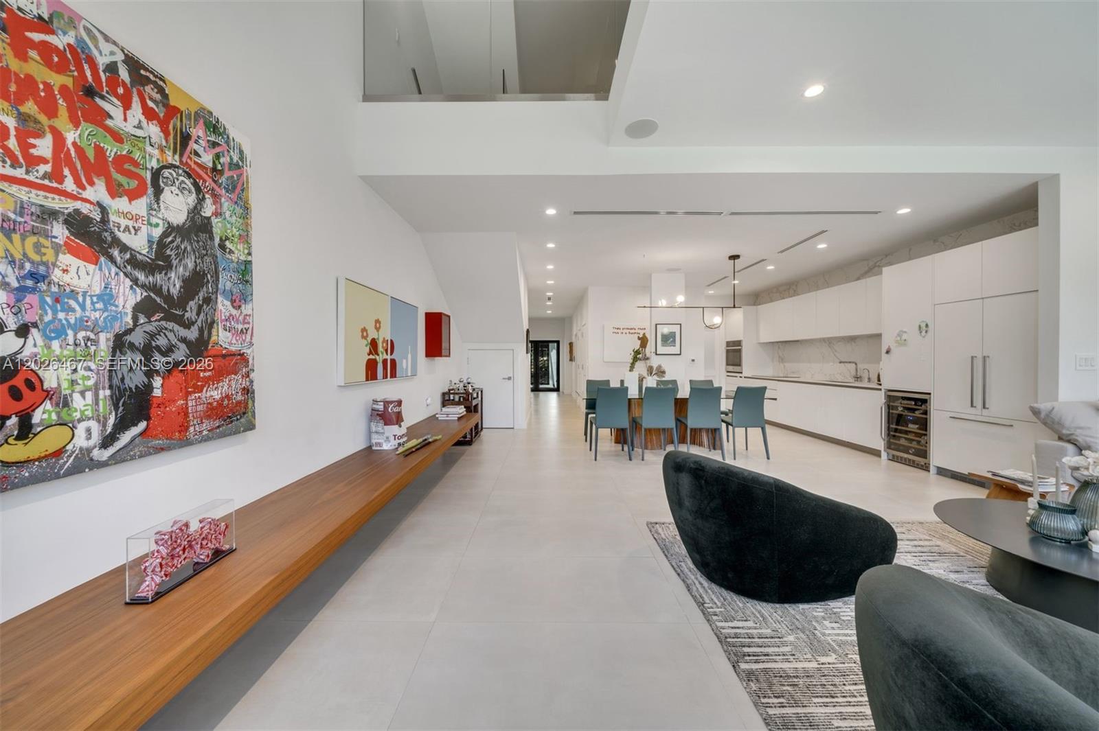 A modern, open-plan living and dining area features white tile floors and contemporary artwork — 10659 NE Quaybridge Ct # C5, Miami FL 33138, MIAMI, FL