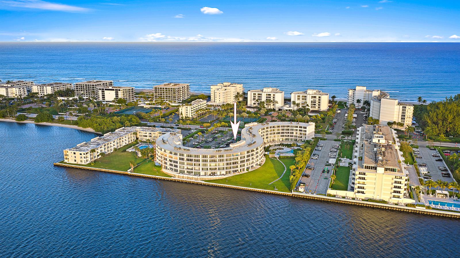 An aerial view of a curved waterfront apartment complex with a parking lot and ocean — 2760 S Ocean Boulevard # 310, Palm Beach FL 33480, PALM BEACH, FL
