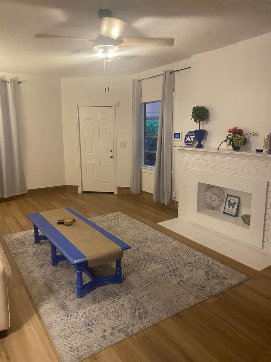 A living room features a white brick fireplace, a blue coffee table, and wood flooring — 631 46th Street, West Palm Beach FL 33407, WEST PALM BEACH, FL