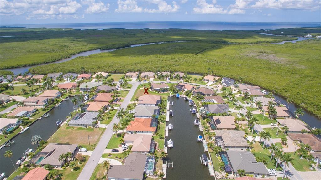 An aerial view shows a residential neighborhood with houses along a canal near mangroves — 760 ANTALYA COURT, PUNTA GORDA, FL