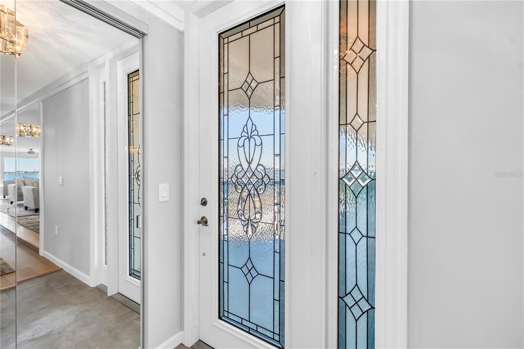 A white front door with decorative leaded glass panels and a matching side light — 6020 SHORE BOULEVARD S UNIT 712, GULFPORT, FL