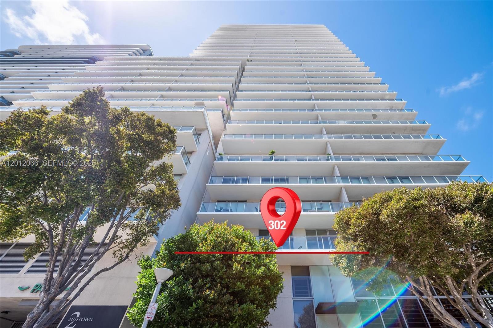 A low-angle exterior view shows a tall residential high-rise building with multiple balconies — 3470 E Coast Ave # H0302, Miami FL 33137, MIAMI, FL