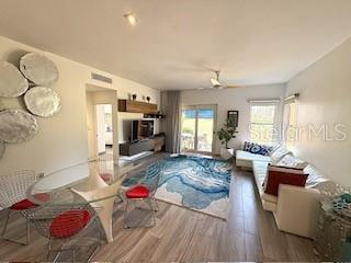 A living room features a blue patterned area rug, a white sofa, and dining furniture — 1 PALMAS DORADAS UNIT 513, HUMACAO, PR