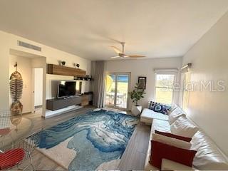 A living room features a large blue patterned rug, a white sectional sofa, and a television — 1 PALMAS DORADAS UNIT 513, HUMACAO, PR