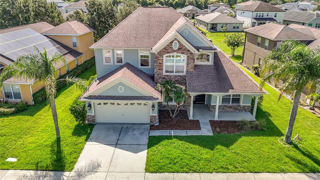 An aerial view of a two-story suburban house with a garage and a front lawn — 4736 POINTE O WOODS DRIVE, WESLEY CHAPEL, FL