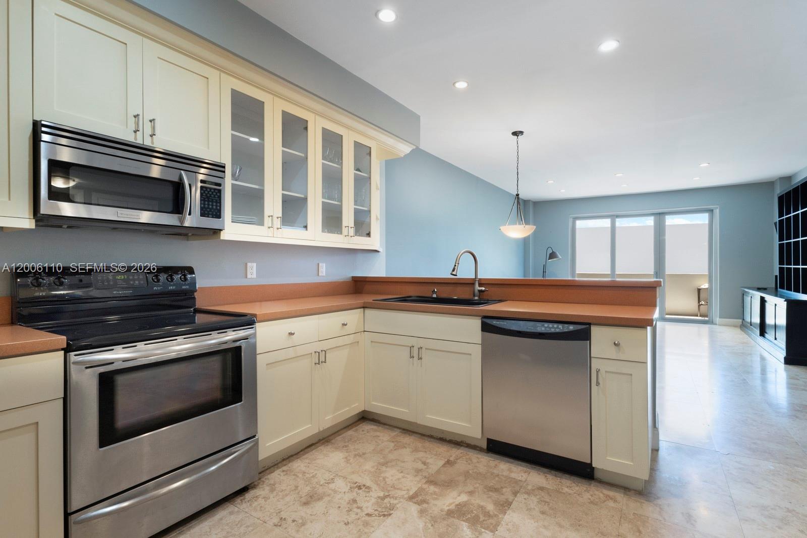 A kitchen with cream cabinets, stainless steel appliances, and a terracotta-colored countertop — 5 Island Ave, Miami Beach FL 33139, MIAMI BEACH, FL