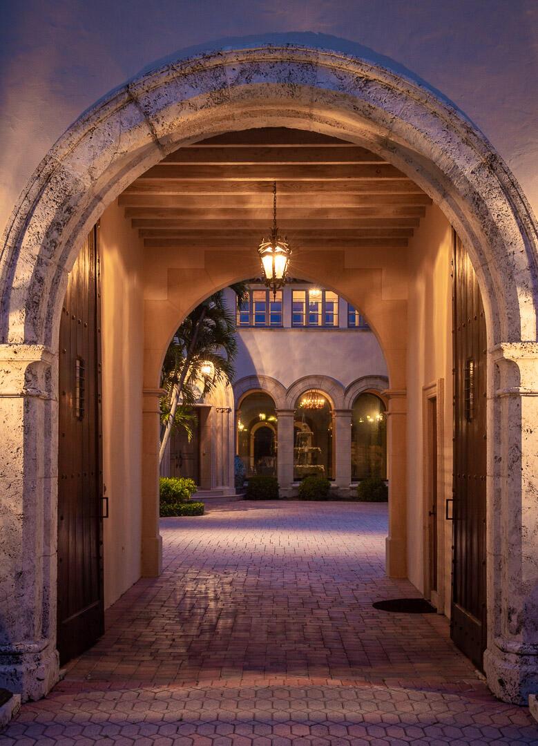 An arched stone entryway leads to a paved courtyard with a fountain and building exterior — 790 S County Road, Palm Beach FL 33480, PALM BEACH, FL