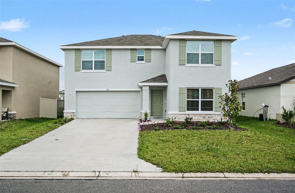 A two-story suburban house with light gray stucco, green shutters, and a two-car garage — 3601 CAPITAL RESERVE DRIVE, PLANT CITY, FL
