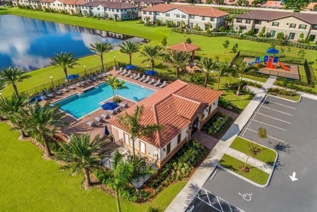 An aerial view of a community pool, clubhouse, playground, and parking lot near a lake — 12932 Anthorne Lane, Boynton Beach FL 33436, BOYNTON BEACH, FL