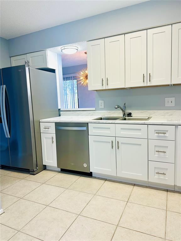 A kitchen features white cabinets, stainless steel appliances, and a light-colored countertop — 2200 BAHIA VISTA ST UNIT B3, SARASOTA, FL