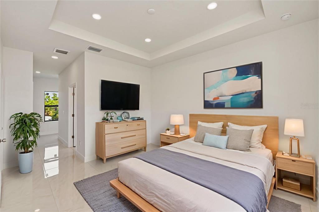 A modern bedroom features a platform bed, light wood furniture, a television, and tile flooring — 15089 ALDAMA CIRCLE, PORT CHARLOTTE, FL