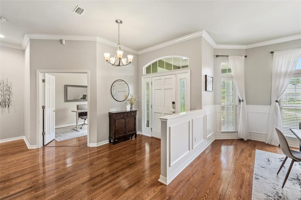 A foyer with hardwood floors, a white half-wall, and a doorway leading to an office — 3782 SW 105TH STREET, GAINESVILLE, FL