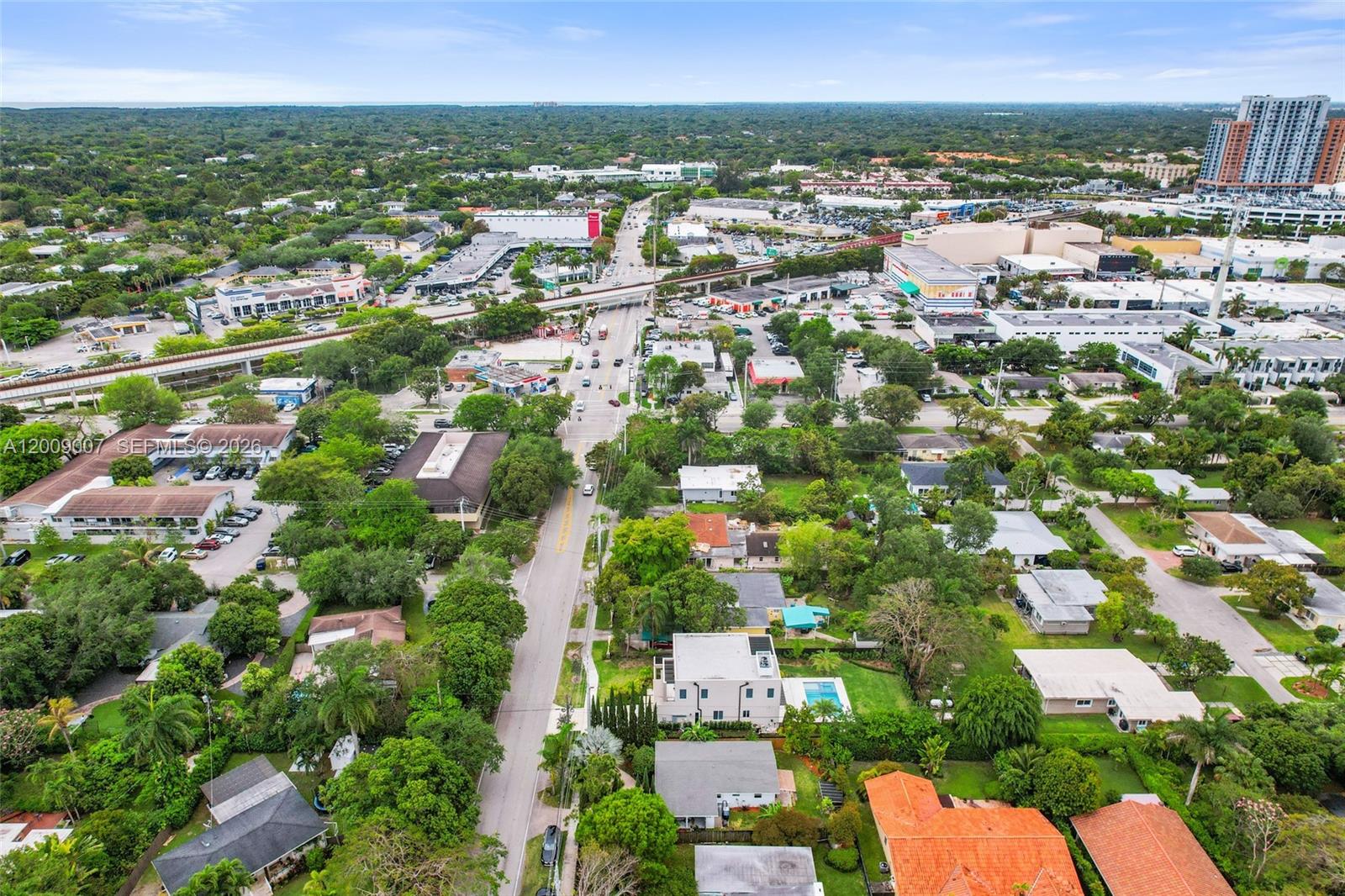 An aerial view shows a suburban neighborhood with houses, trees, and a nearby commercial area — 7840 SW 67th Ave, South Miami FL 33143, SOUTH MIAMI, FL