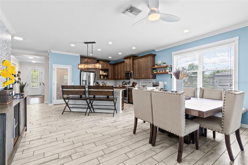 A kitchen features dark wood cabinets, stainless steel appliances, granite countertops, and light tile flooring — 13353 BATTEN LANE, ODESSA, FL