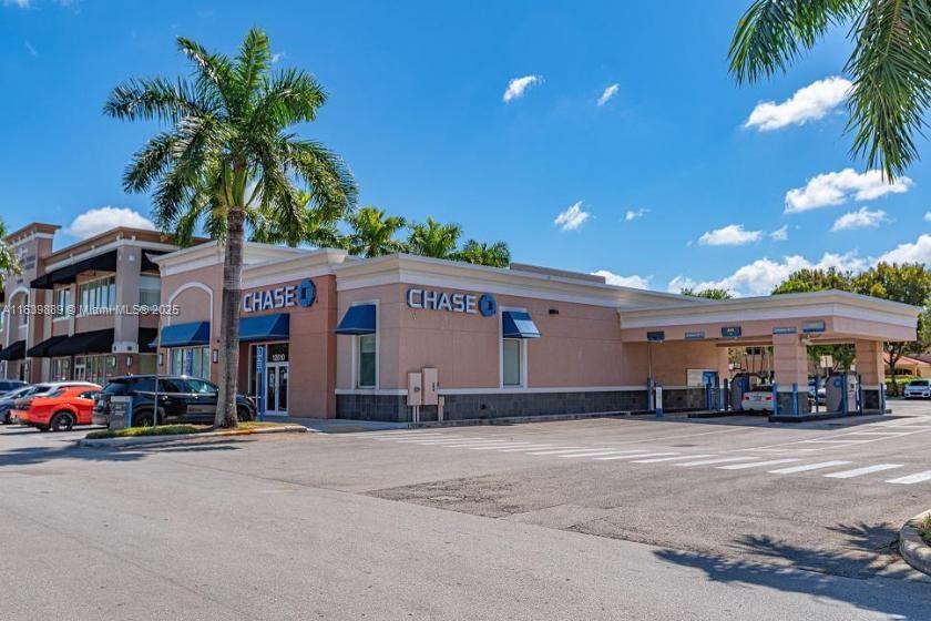 A Chase bank branch features a drive-thru lane and a parking lot under a blue sky — 12610 SW 120th St, Miami FL 33186, MIAMI, FL