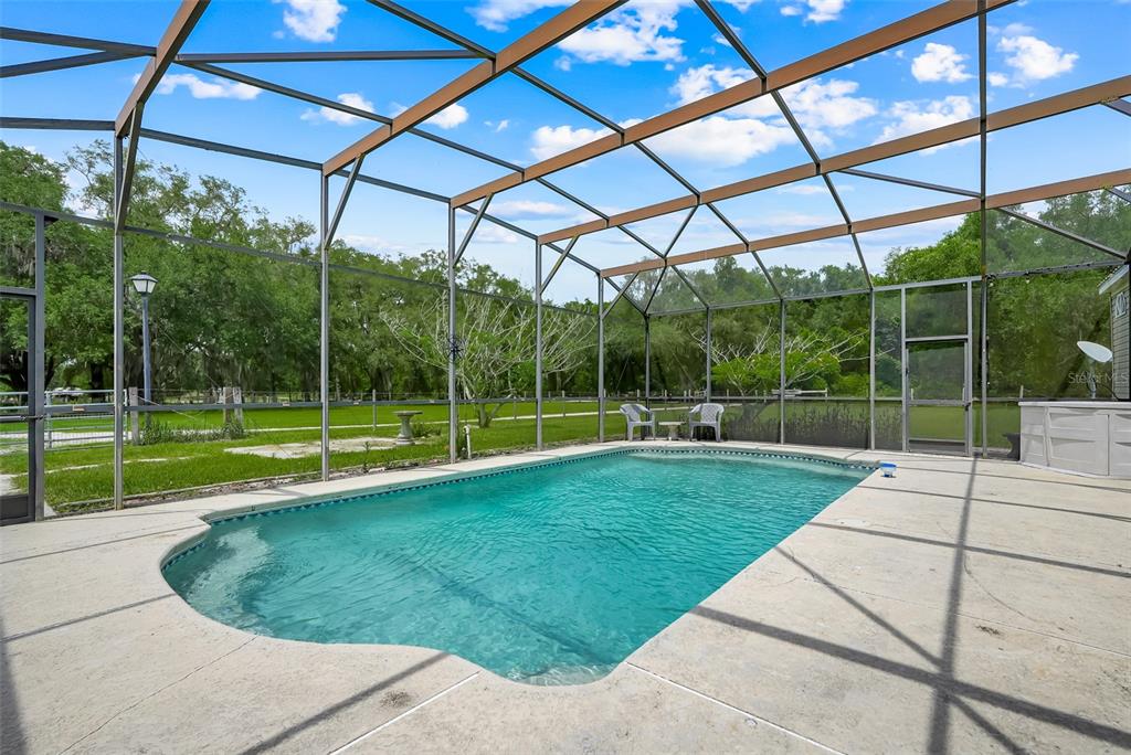 A single-story manufactured home with light siding, a red star accent, and a wooden deck — 21301 QUAIL HAMMOCK LANE, GROVELAND, FL