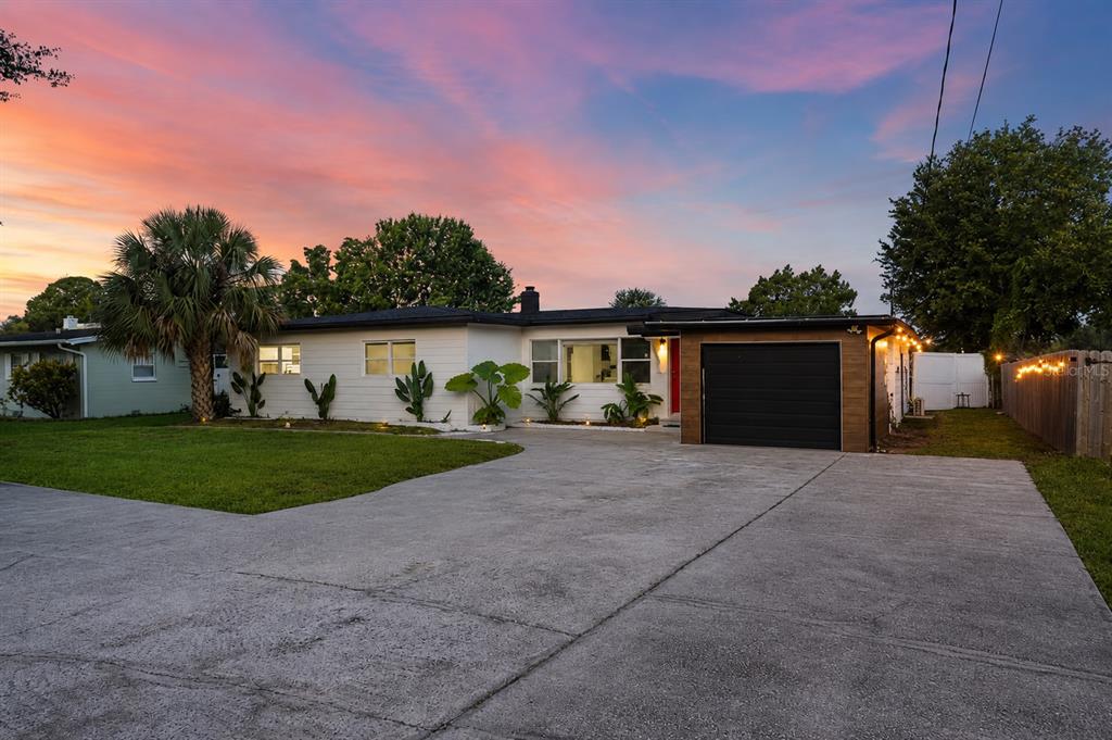A single-story house with a white exterior, a black garage door, and a concrete driveway — 8120 GONDOLA DRIVE, ORLANDO, FL