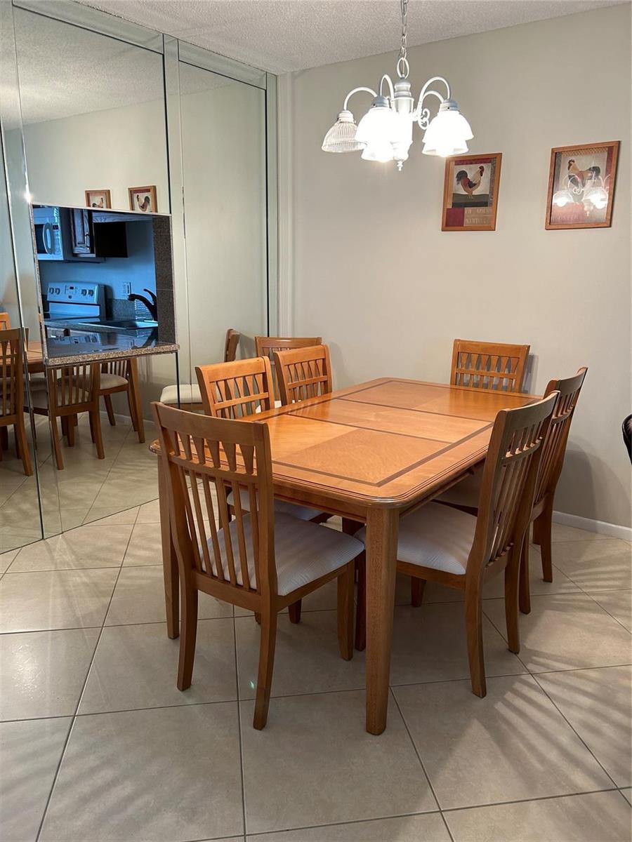 A kitchen features oak cabinets, granite countertops, a window with blinds, and white appliances — 601 NW 76th Terrace # 206, Margate FL 33063, MARGATE, FL