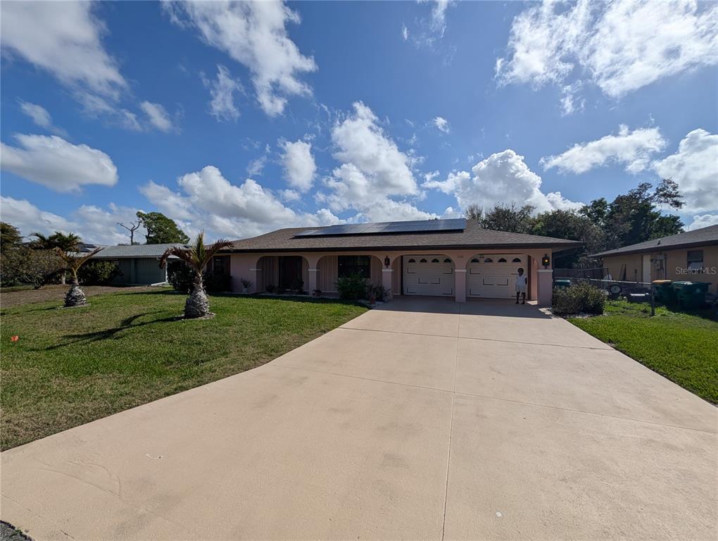 A single-story house with a two-car garage, solar panels, and a concrete driveway — 3280 GLENCOVE STREET, PUNTA GORDA, FL