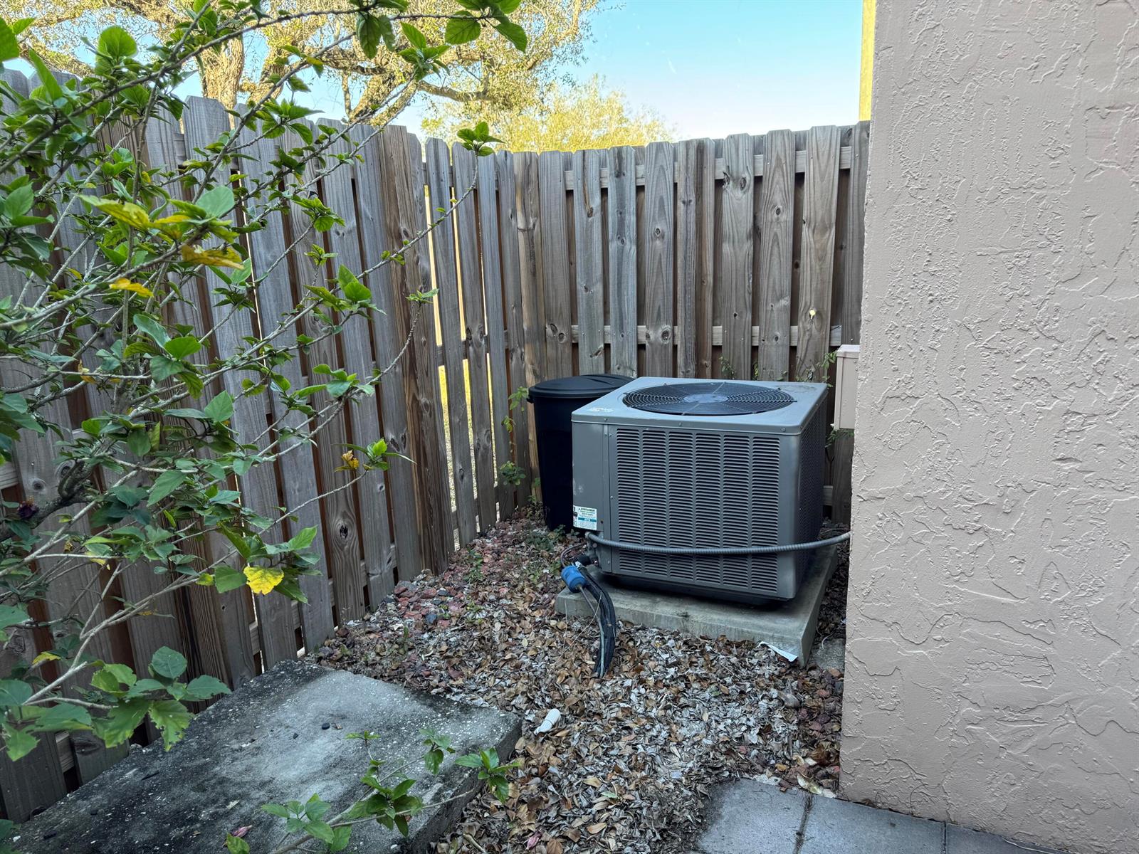 An outdoor air conditioning unit sits on a concrete pad next to a wooden fence — 31 Chestnut Circle, Cooper City FL 33026, COOPER CITY, FL