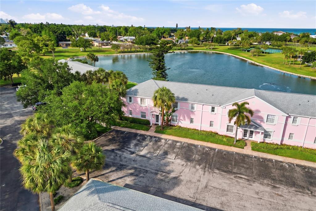 An aerial view shows a pink two-story building next to a lake and parking lot — 4754 COBIA DRIVE SE UNIT D, ST PETERSBURG, FL