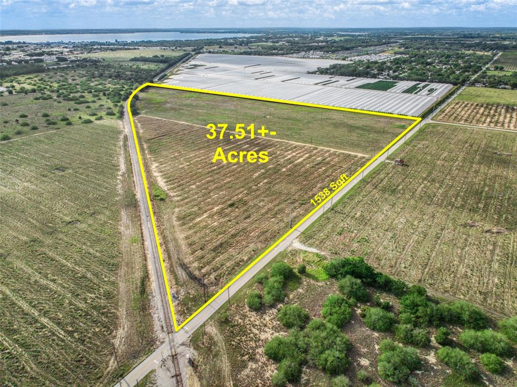 An aerial view shows a triangular plot of land outlined in yellow near railroad tracks — 4199 DESOTO CITY ROAD, SEBRING, FL