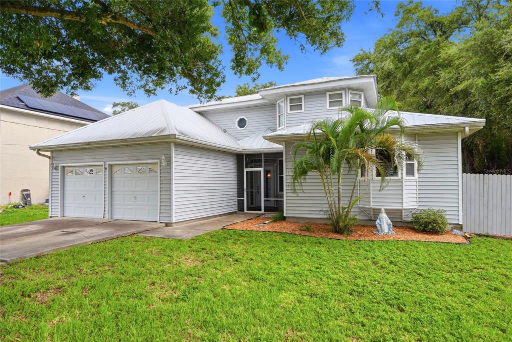 A two-story house with light gray siding, a metal roof, and a two-car garage — 9121 65TH STREET N, PINELLAS PARK, FL