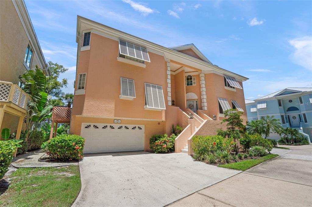 A three-story peach-colored house with a two-car garage and an elevated front entrance — 3954 HAMILTON CLUB CIRCLE UNIT 14, SARASOTA, FL