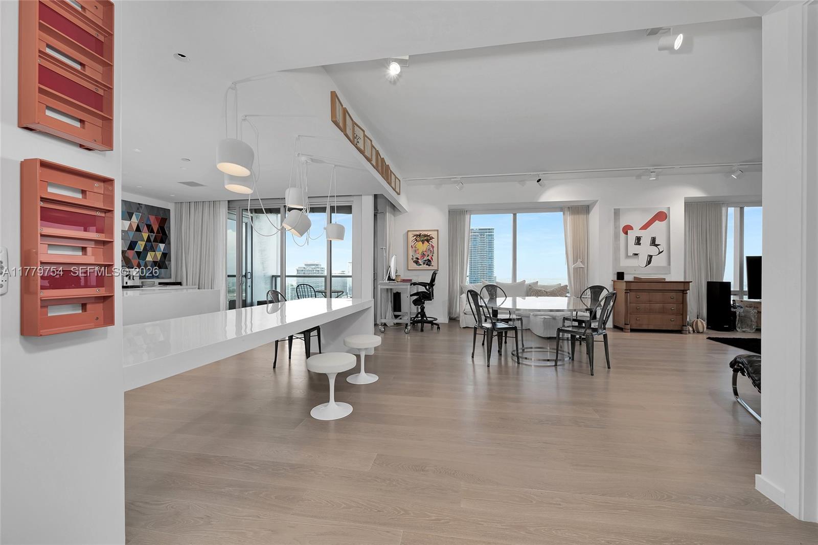 A bright, open-concept living and dining area features light wood floors and floor-to-ceiling windows — 1425 Brickell Ave # 61E, Miami FL 33131, MIAMI, FL