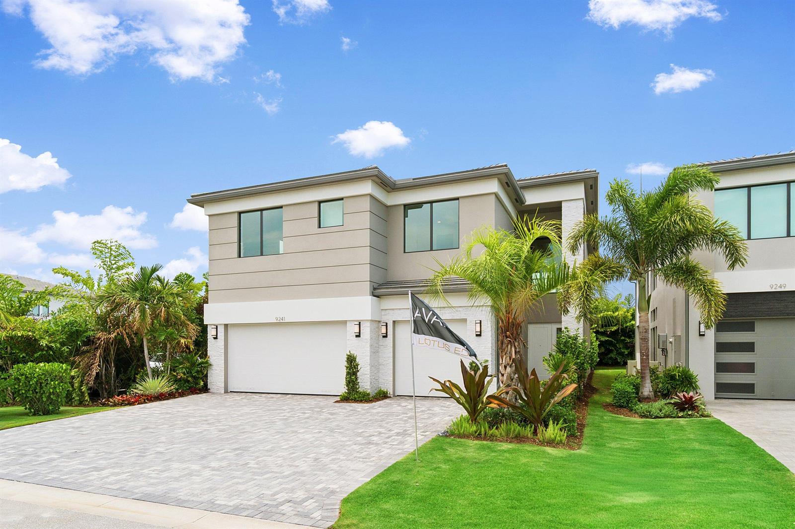 A two-story modern house features a paved driveway, a two-car garage, and palm trees — 9241 Sunflower Meadow Road, Boca Raton FL 33434, BOCA RATON, FL