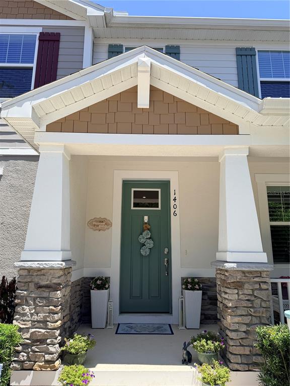 The front entrance features a teal door, stone-based columns, and a gabled roof porch — 1406 BLUMBERG BOULEVARD, WINTER SPRINGS, FL