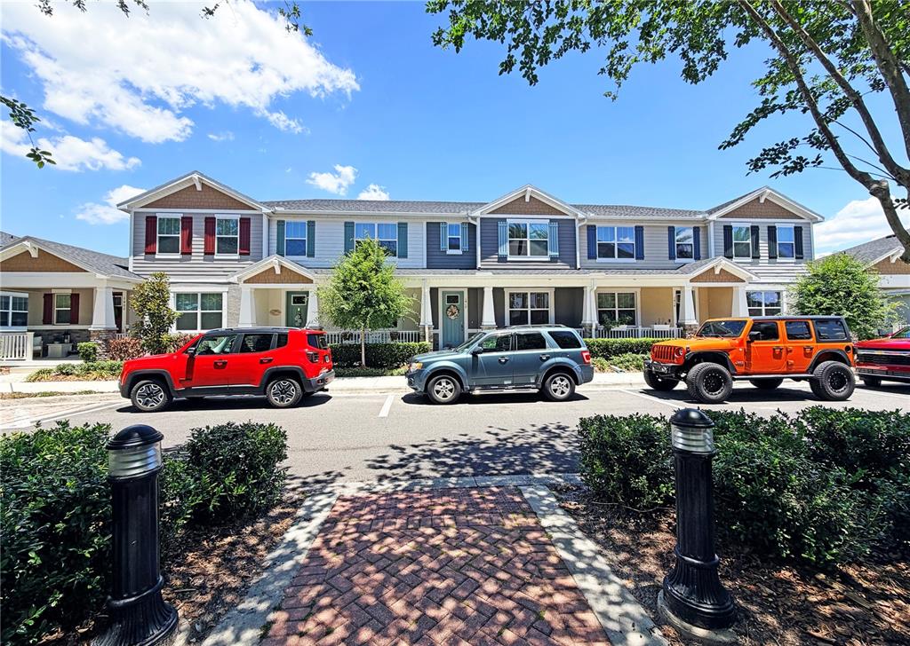 A row of multi-story townhomes with parked cars in front under a blue sky — 1406 BLUMBERG BOULEVARD, WINTER SPRINGS, FL