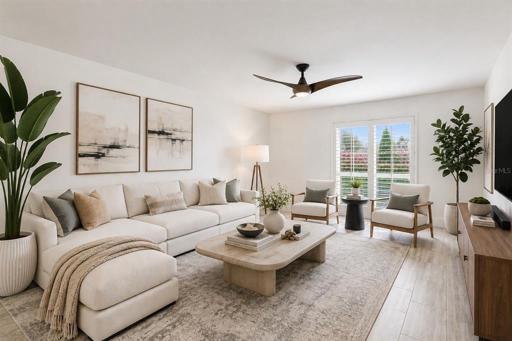 A bright living room features a white sectional sofa, coffee table, two armchairs, and plants — 1101 88TH AVENUE N, ST PETERSBURG, FL