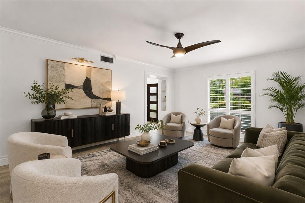 A modern living room features a dark green sofa, cream armchairs, and a black coffee table — 1101 88TH AVENUE N, ST PETERSBURG, FL