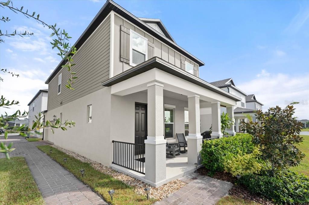 A two-story house exterior features a covered front porch with columns and a black door — 2916 MELETO BOULEVARD, NEW SMYRNA BEACH, FL