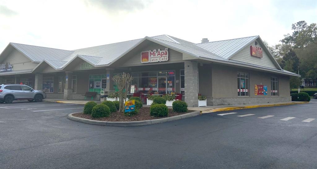 A single-story commercial building with a metal roof and a Mi Apá Latin Café sign — 15634 NW US HIGHWAY 441 UNIT D, ALACHUA, FL