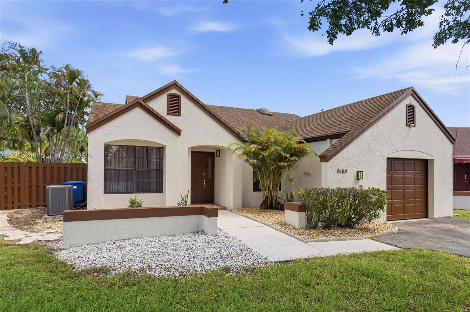 A single-story house with a stucco exterior, brown trim, a front garage, and a walkway — 8165 NW 187th Ter, Hialeah FL 33015, HIALEAH, FL