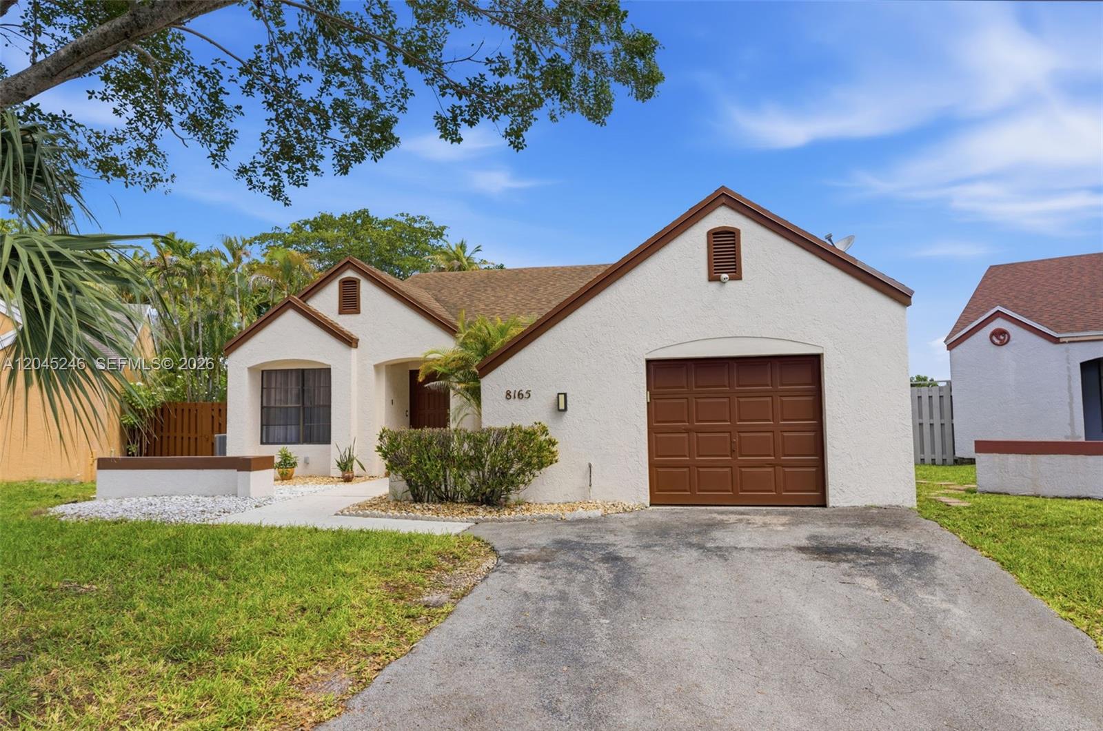 A single-story house with a white stucco exterior, brown trim, and a one-car garage — 8165 NW 187th Ter, Hialeah FL 33015, HIALEAH, FL