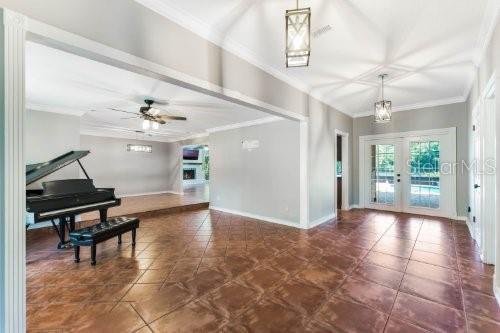 A living area features a grand piano on a tiled floor with a view into another room — 306 N SWEETWATER COVE BOULEVARD, LONGWOOD, FL