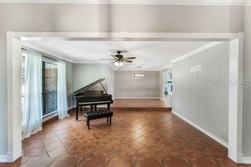 A room with tile flooring features a grand piano and a raised platform area — 306 N SWEETWATER COVE BOULEVARD, LONGWOOD, FL