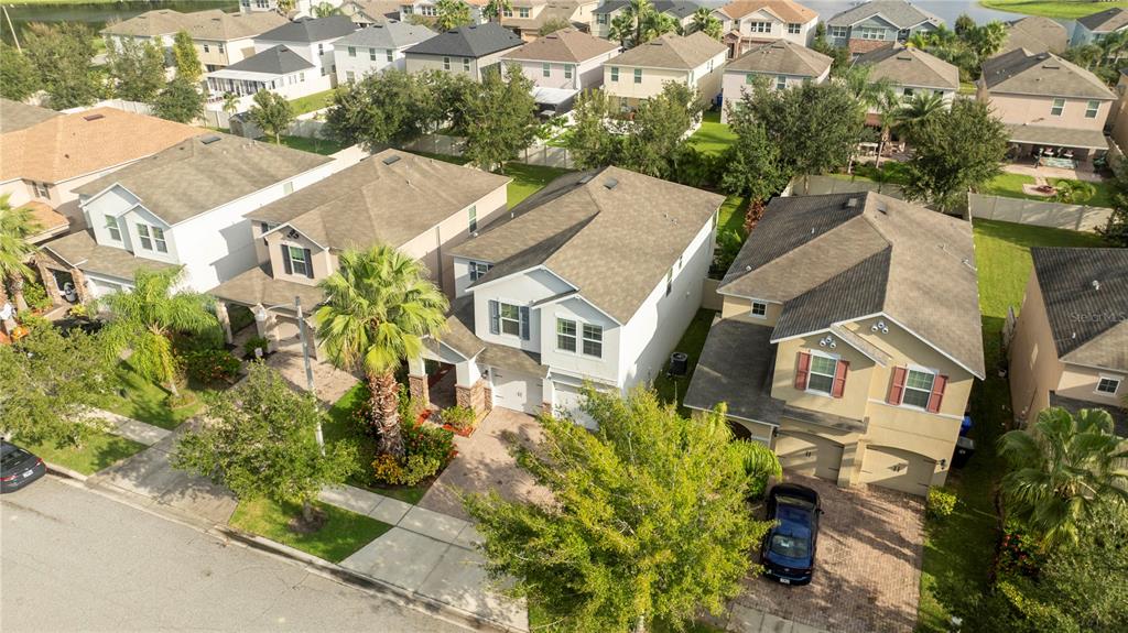 A covered entryway features a paver floor, a dark front door, and stone-clad pillars — 2658 SAN SIMEON WAY, KISSIMMEE, FL