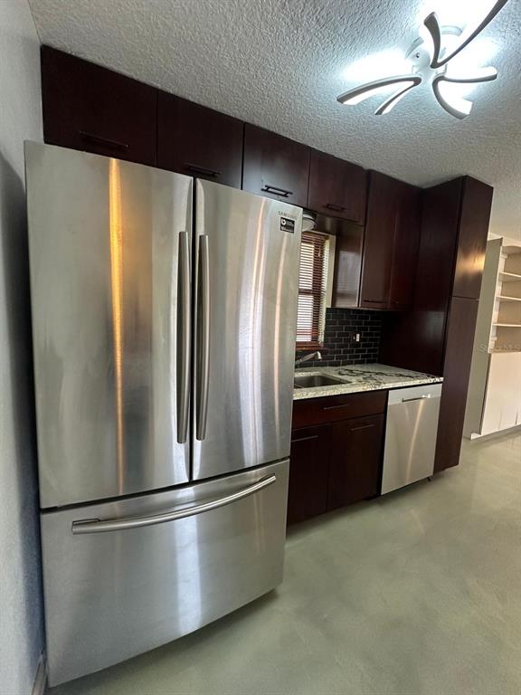A kitchen features dark wood cabinets, stainless steel appliances, and a granite countertop — 1508 MONA AVENUE, OCOEE, FL